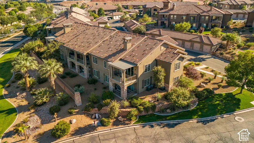 Multi-story building featuring stucco exterior, multiple covered balconies, and a tile roof