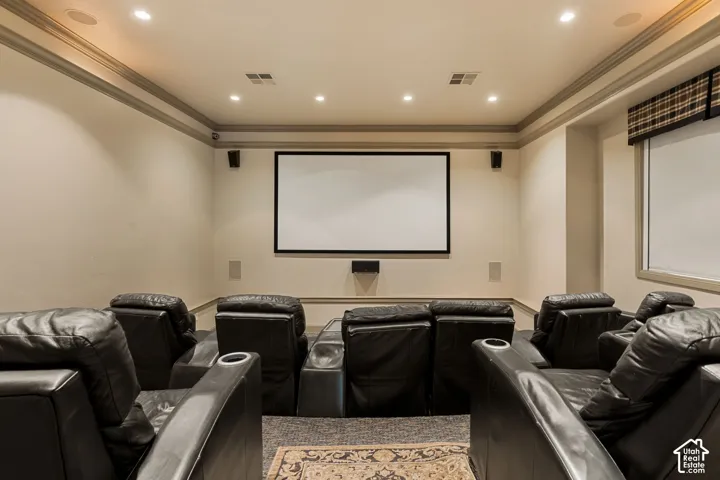 Home theater featuring a large projection screen, recessed lighting, crown molding, and in-wall speakers