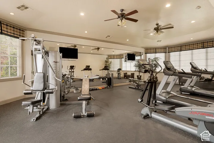 Fitness center with multiple exercise machines, ceiling fans, recessed lighting, and mirrored walls