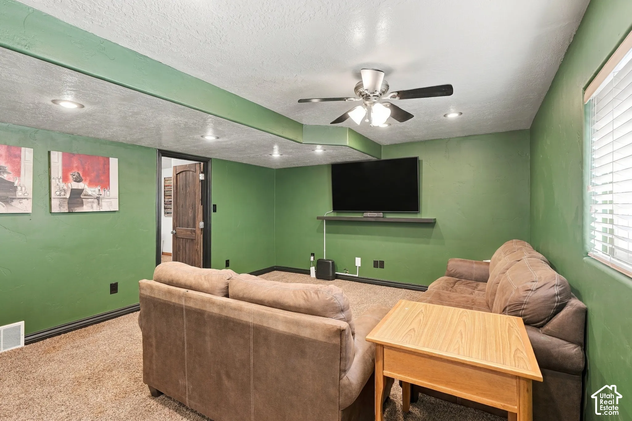 Recessed ceiling lighting, ceiling fan, carpet flooring, a built-in wall shelf, and a window with blinds
