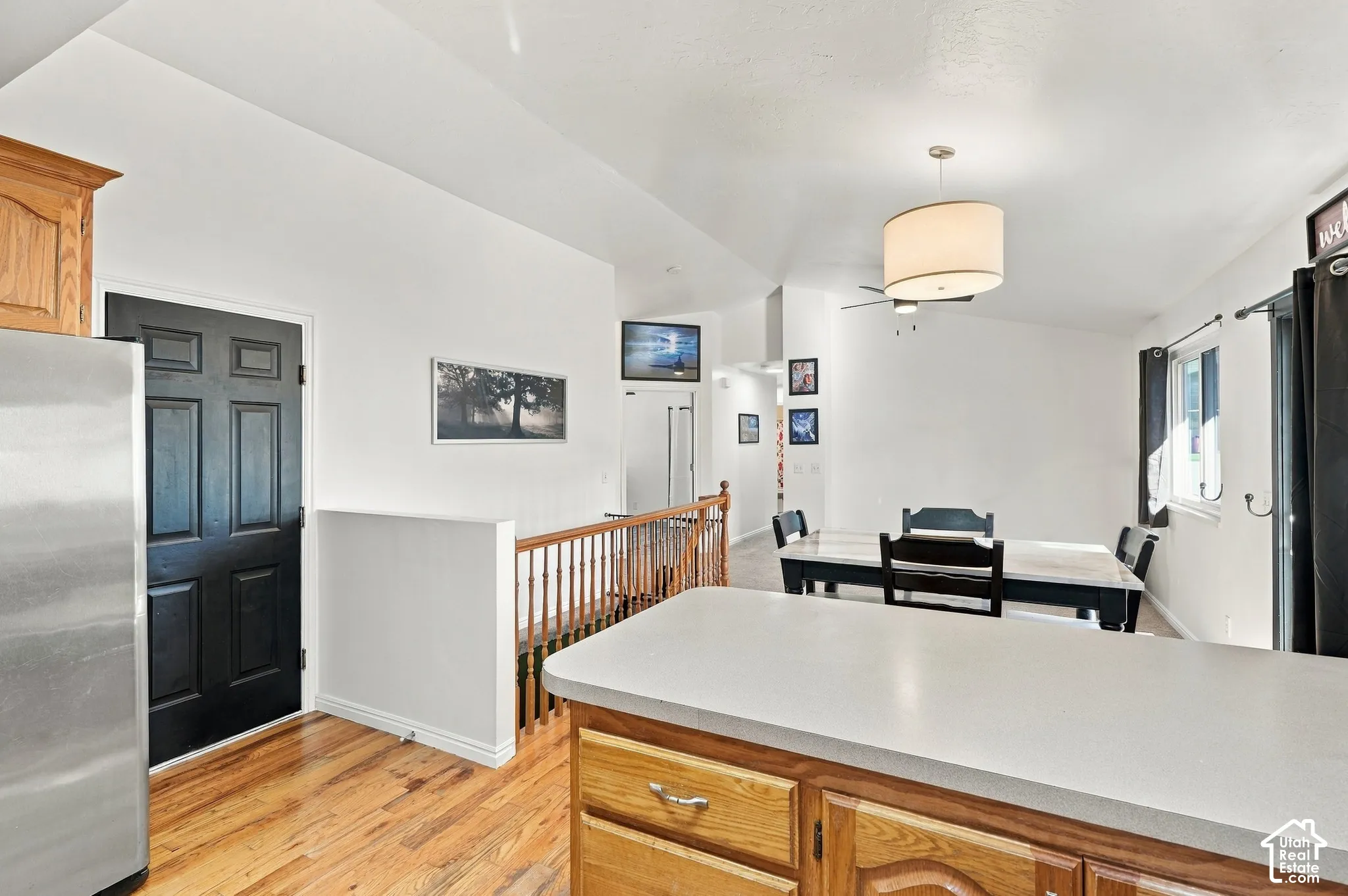 Wood-finish flooring, wood cabinetry with light countertops, and a black paneled door