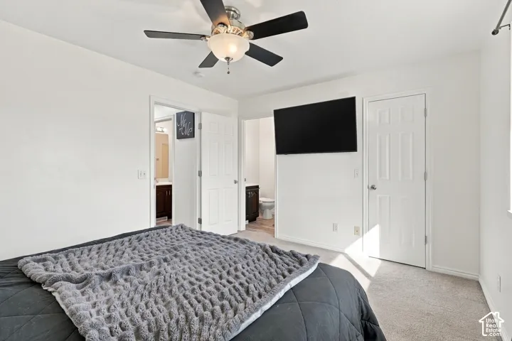 Ceiling fan with integrated lighting, recessed lighting, wall-mounted television, white panel doors, and neutral carpeting