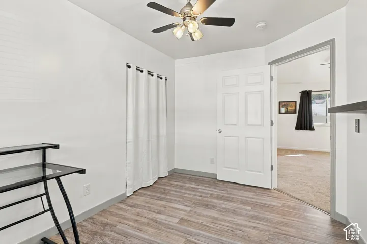 Wood-finish flooring with a neutral paint scheme and a ceiling fan