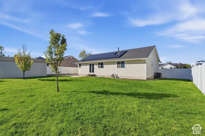 Expansive green lawn with a white privacy fence and a rear patio