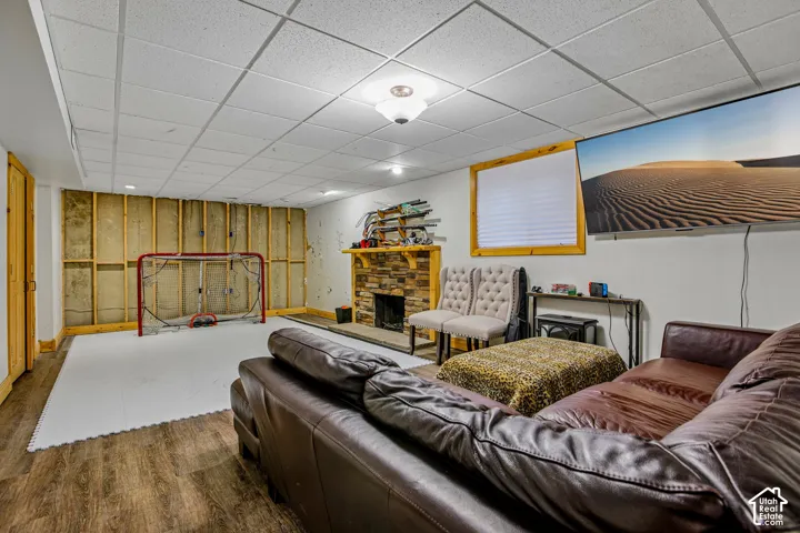 Wood-finish flooring, stone-clad fireplace, and drop ceiling