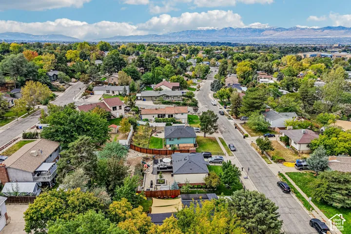 Residential neighborhood with mature trees, paved streets, and distant mountain backdrop