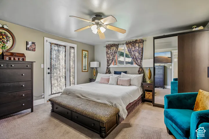 Dual French doors, ceiling fan, carpeted flooring, and wood-finish sliding closet doors