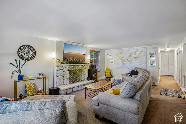 Stone-surround fireplace with a metal fire screen, recessed lighting, and carpeted flooring