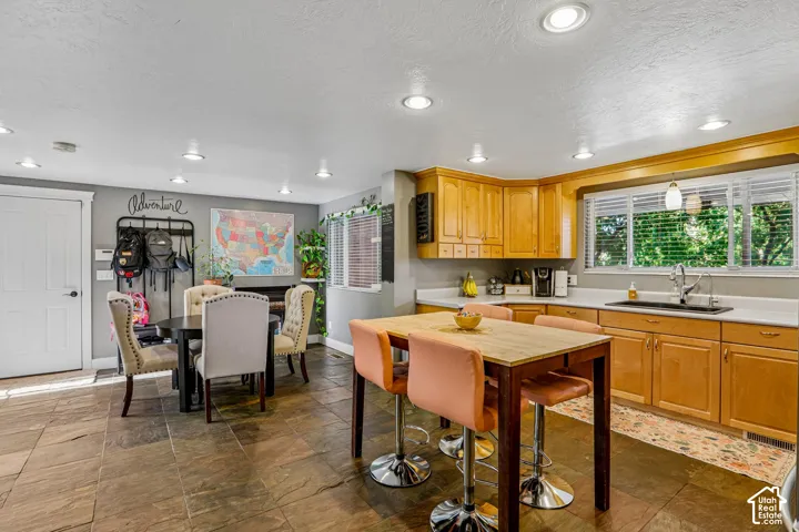 Kitchen featuring wood cabinetry, white countertops, a stainless steel sink with a gooseneck faucet, and recessed lighting