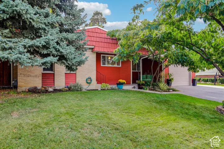 Red siding exterior with a textured red roof, brick accents, and an attached garage