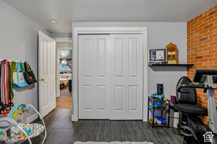 Wood-finish flooring with a brick accent wall and white trim