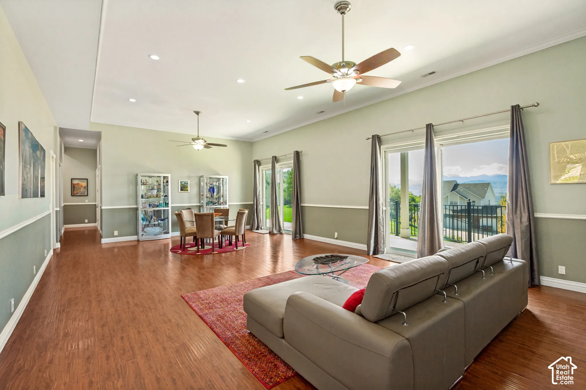 Expansive open-concept living area featuring wood-finish flooring, recessed lighting, and crown molding
