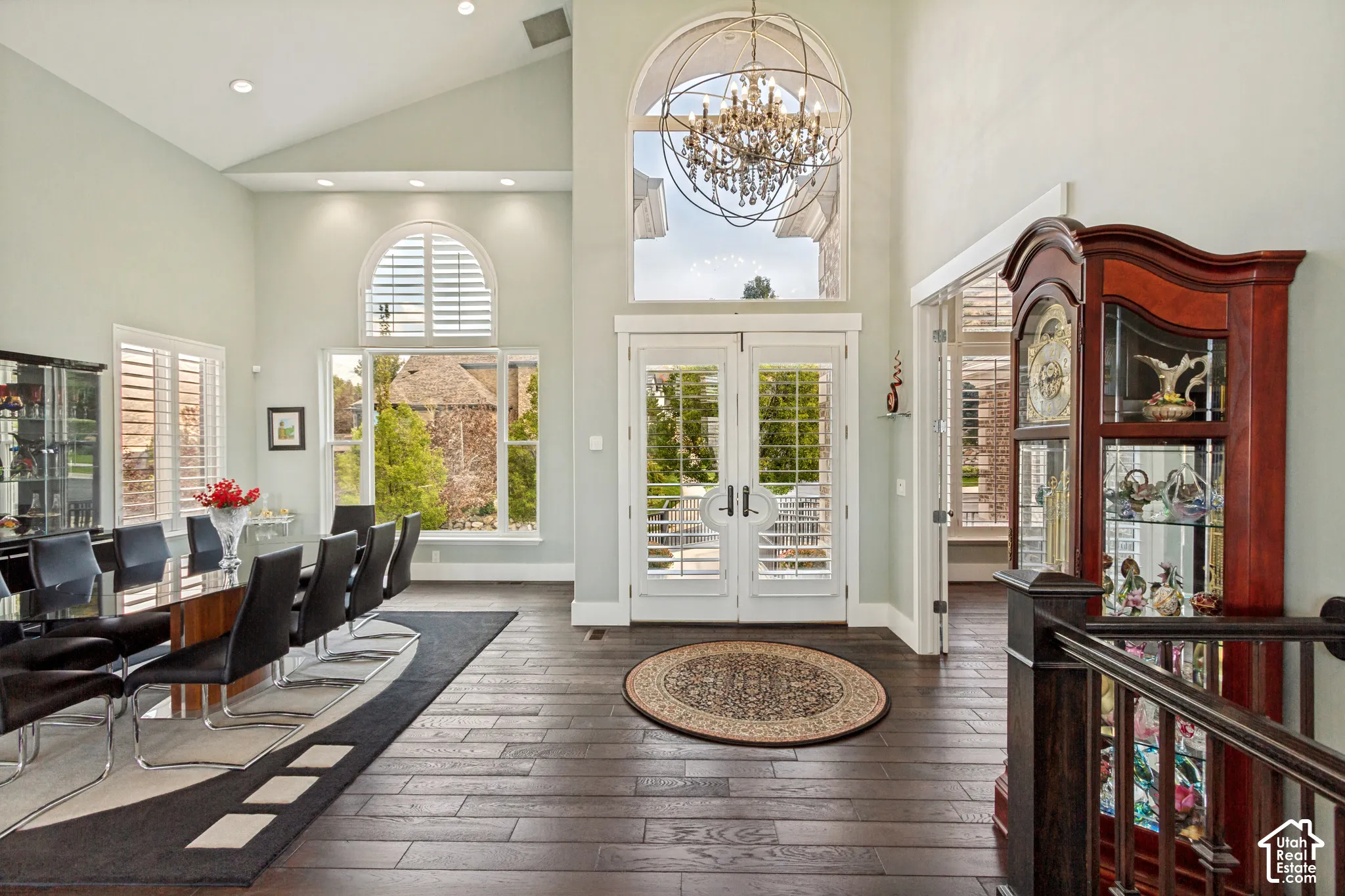 Vaulted ceilings with recessed lighting, dark wood-finish flooring, and white plantation shutters