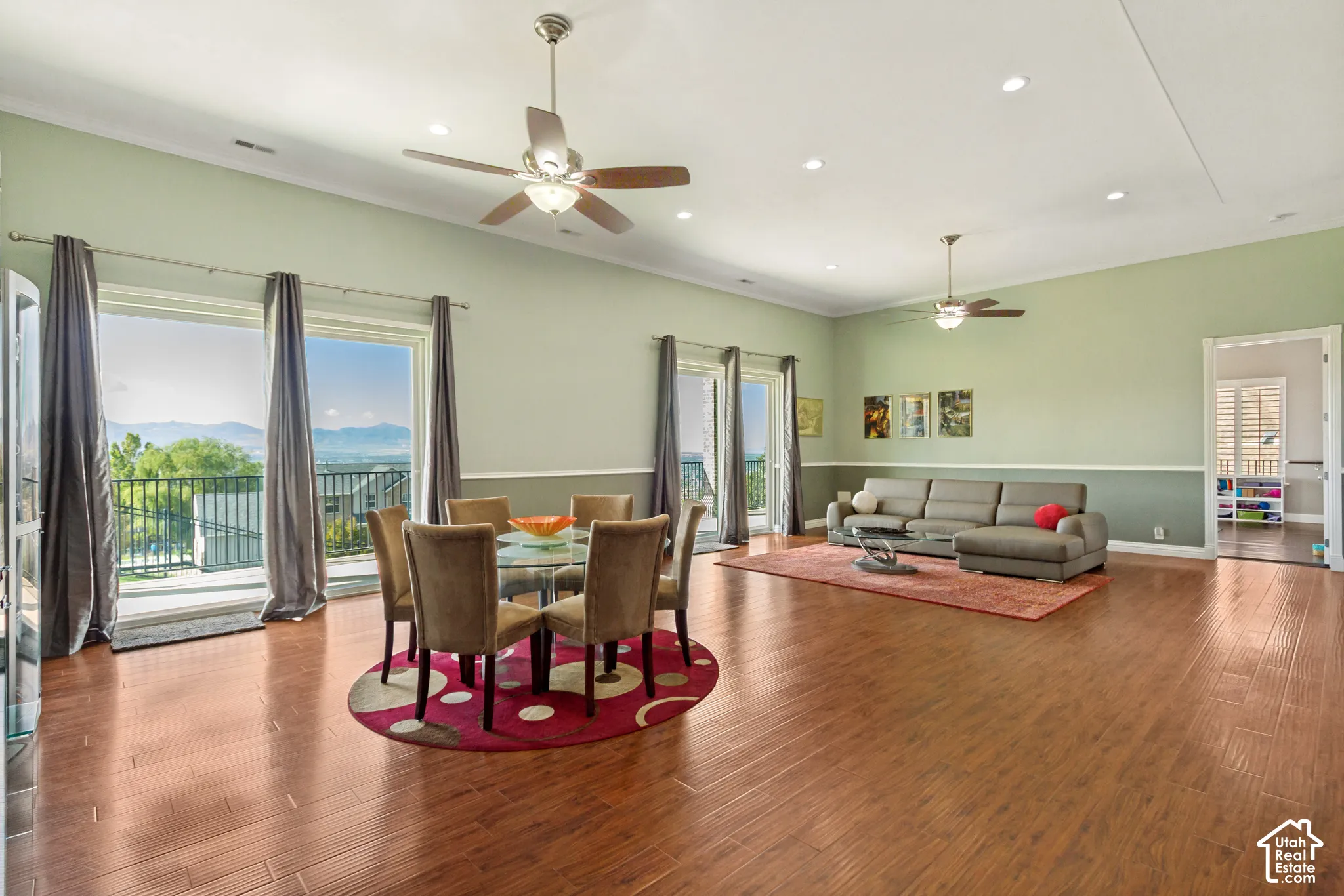 Open-concept living space with wood-finish flooring, recessed lighting, and ceiling fans
