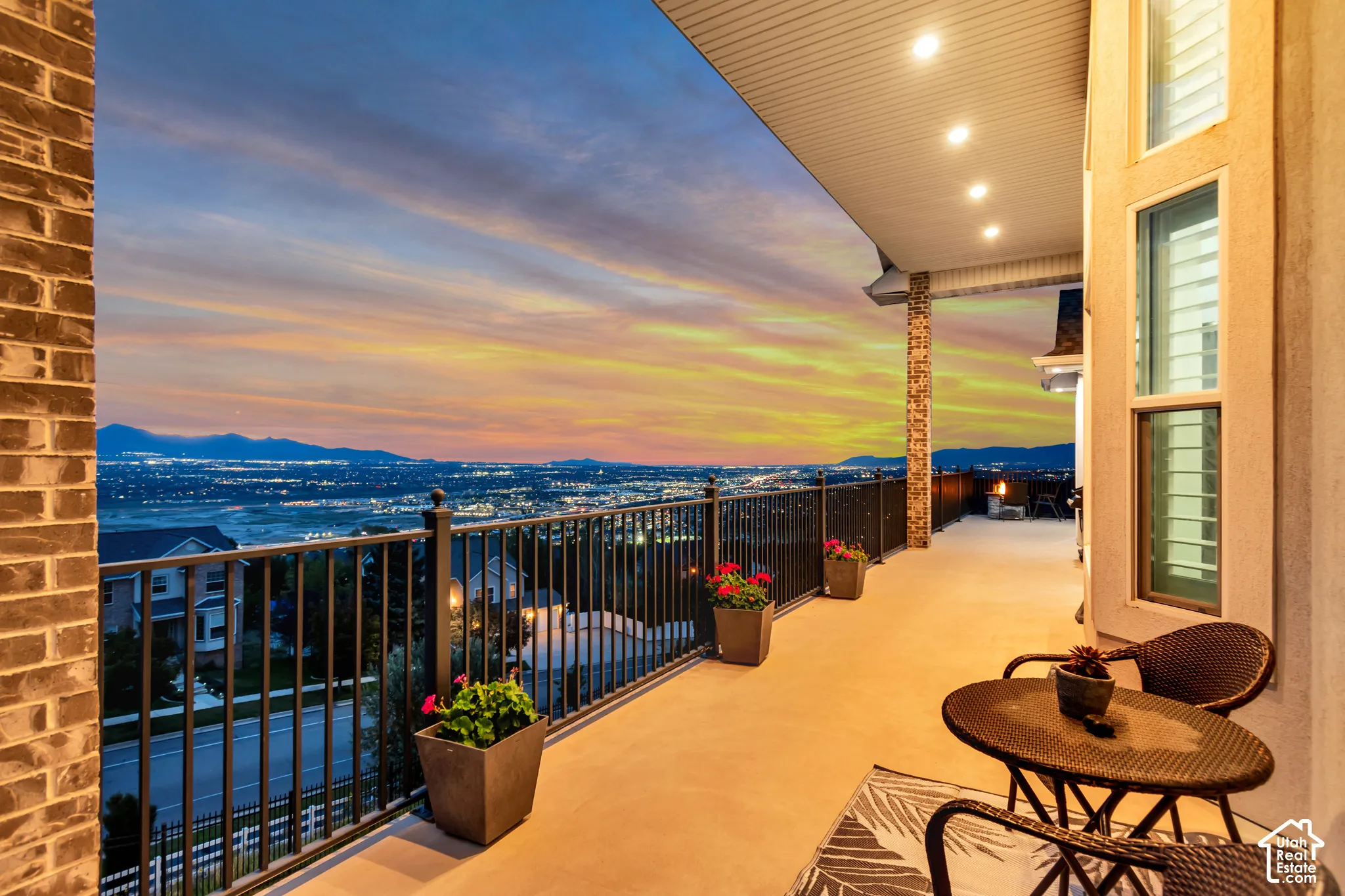 Covered balcony featuring recessed lighting, brick and stone veneer accents, and a metal railing