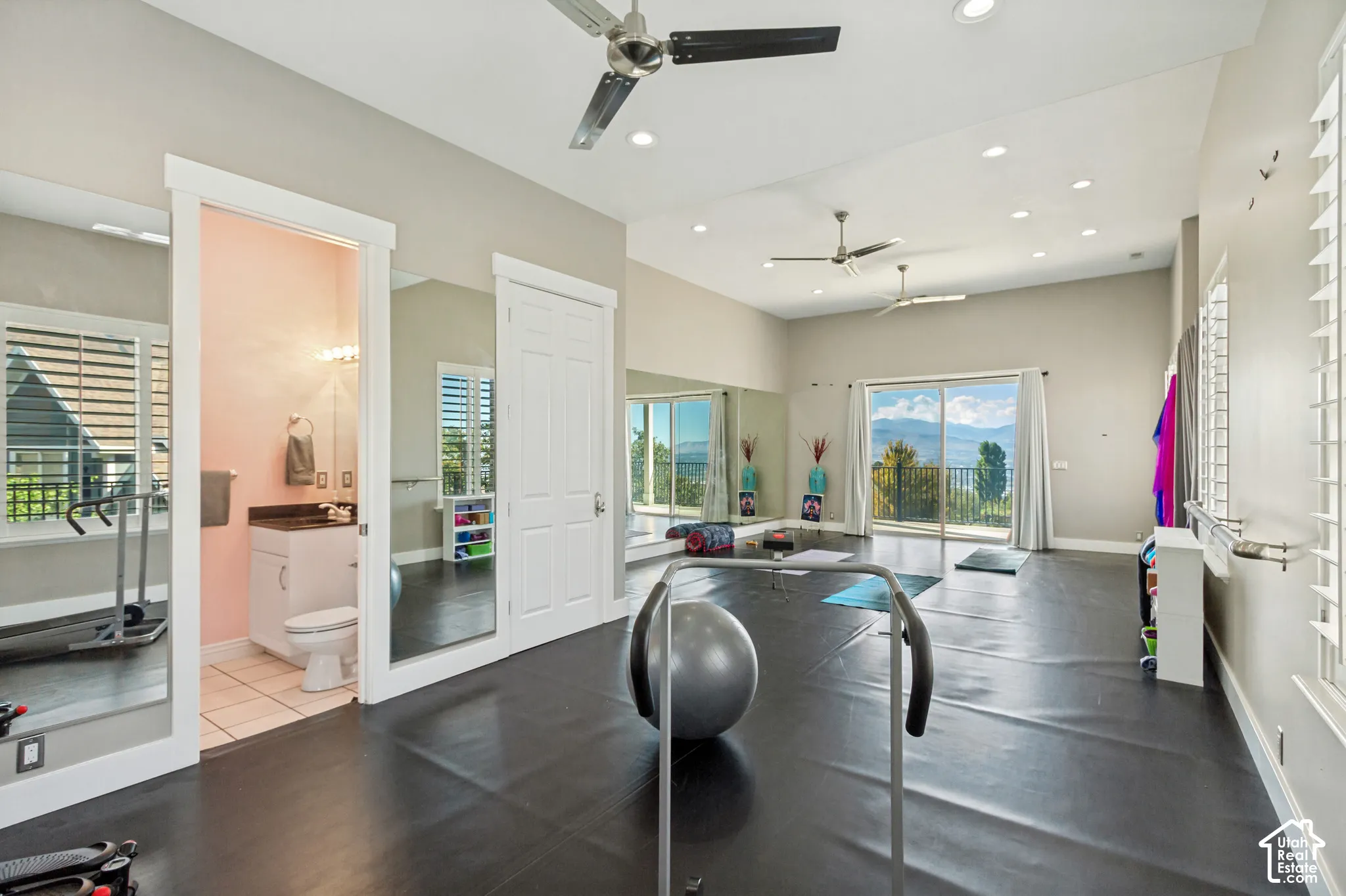 Spacious room featuring vaulted ceilings, recessed lighting, and dark flooring