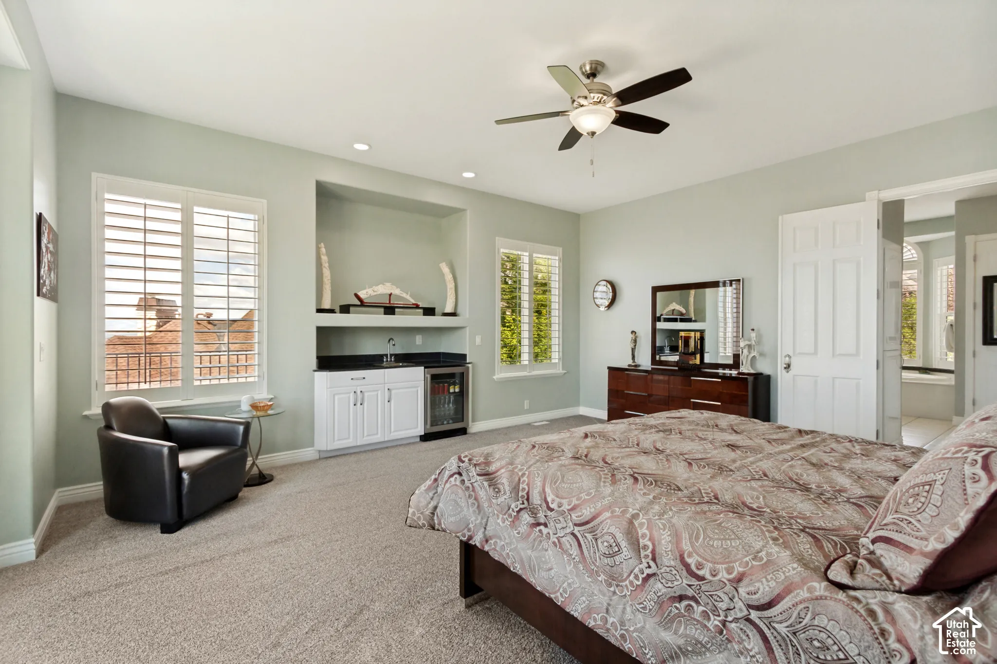Recessed lighting, ceiling fan, built-in wet bar with sink, built-in beverage refrigerator, and plantation shutters