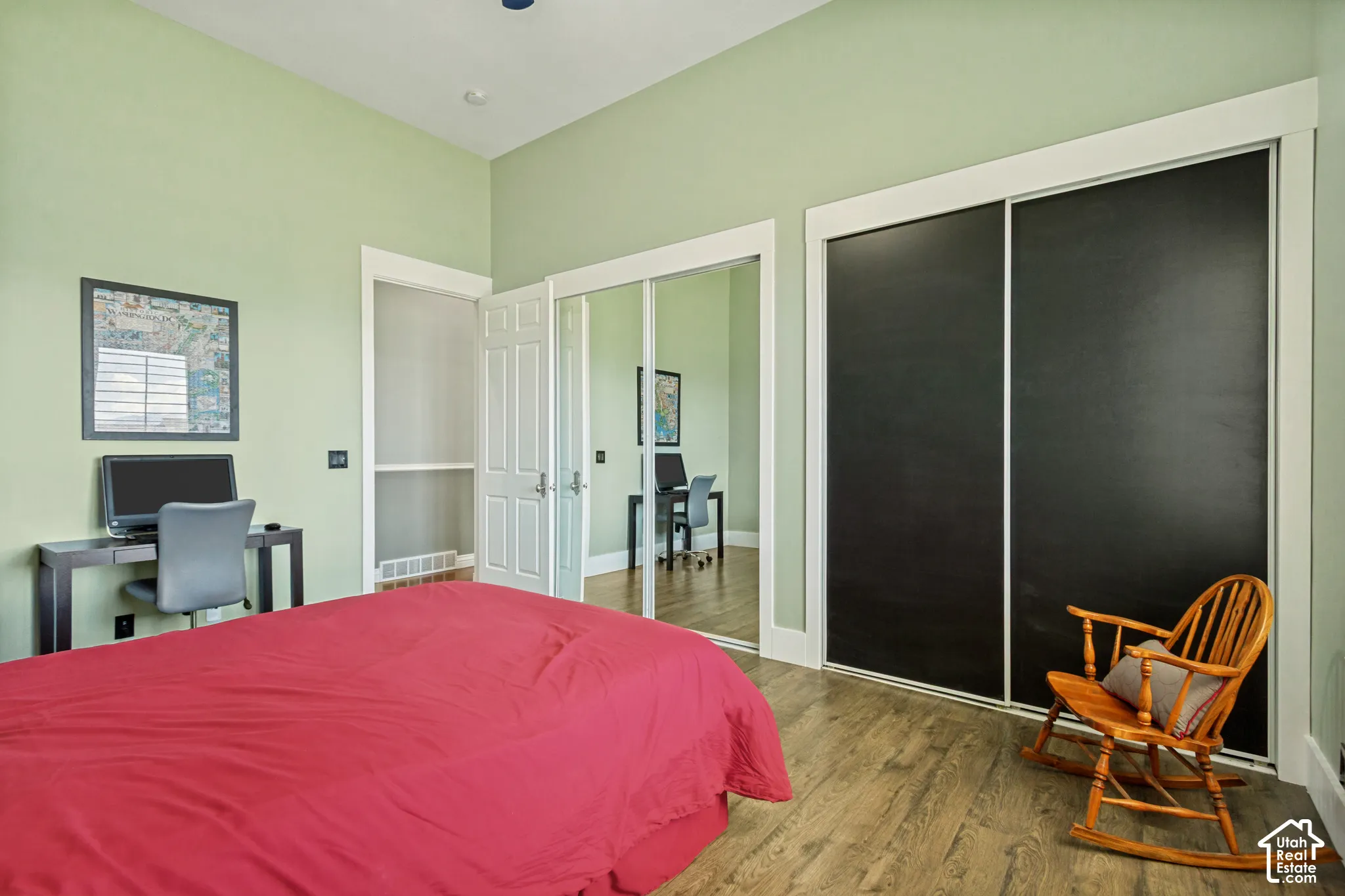 Wood-finish flooring, white trim, and a door with paneling
