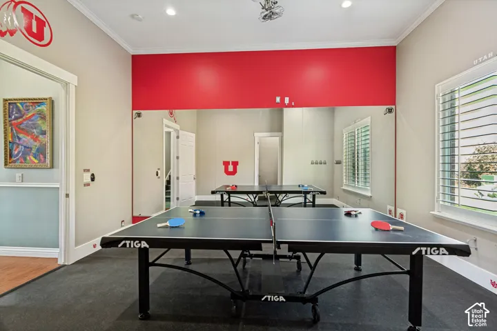 Expansive recreation room featuring a full mirrored wall, durable flooring, and bright accent wall