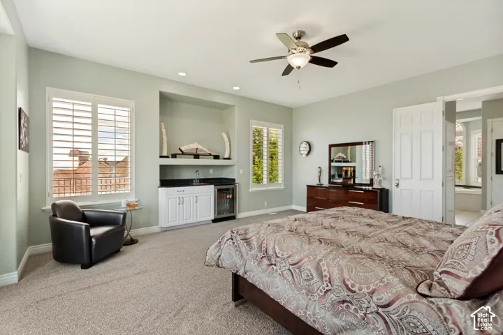 Recessed lighting, ceiling fan, built-in wet bar with sink, built-in beverage refrigerator, and plantation shutters