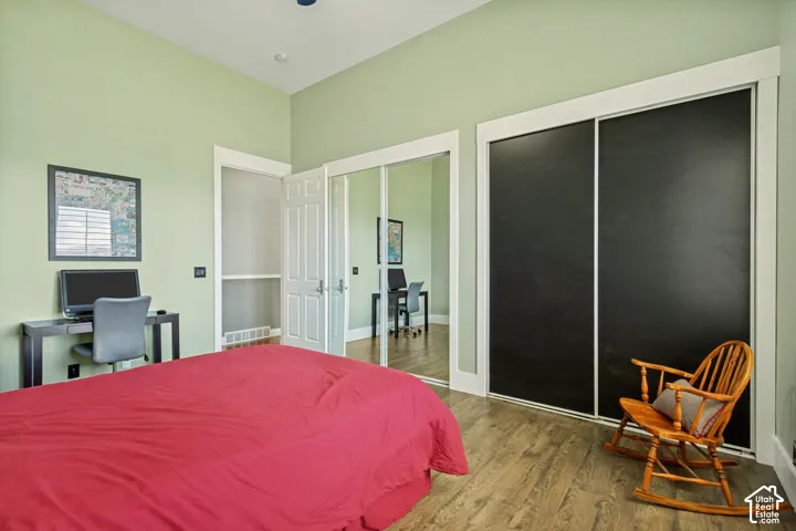 Wood-finish flooring, white trim, and a door with paneling