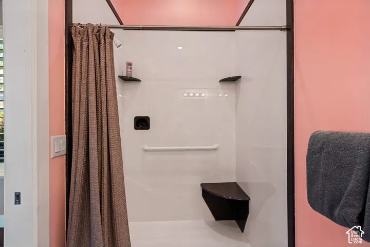 White shower enclosure with integrated bench and grab bar