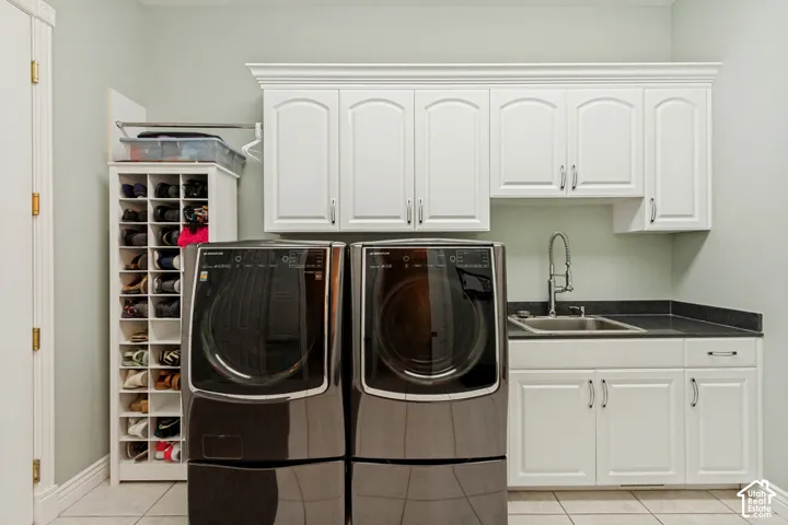 Laundry area featuring white cabinetry, a utility sink, and stone-finish countertops