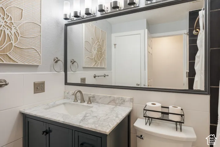 Spa-inspired bathroom featuring a marble-topped vanity with an undermount sink, matte black hardware, and custom cabinetry
