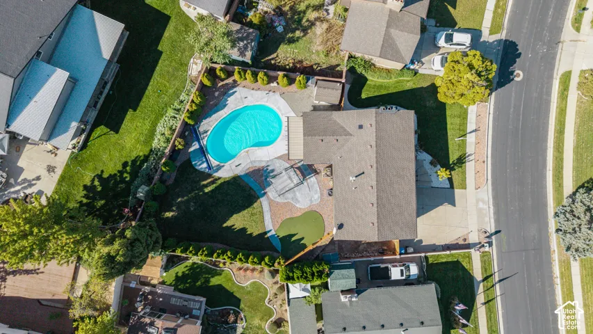 Kidney-shaped in-ground pool surrounded by hardscaping
