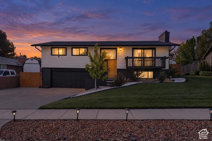 Modern split-level home featuring a clean contemporary facade with horizontal band windows, illuminated interior spaces, and a welcoming front entry