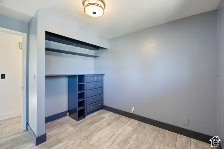 Dedicated dressing room featuring custom built-in cabinetry with multiple drawers, open shelving, and a clothing rod system