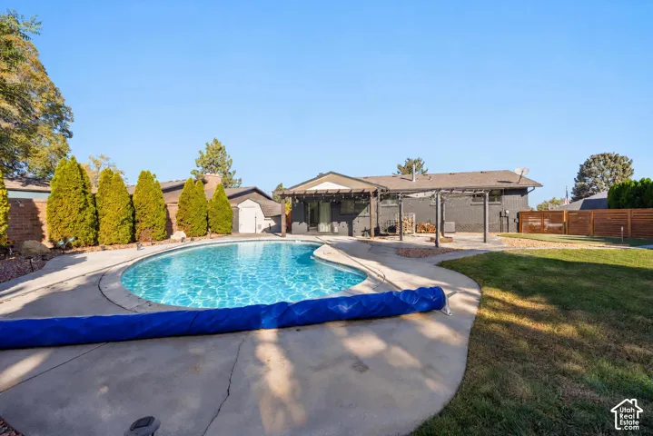 Expansive backyard oasis featuring a resort-style saltwater pool with curved perimeter, concrete decking, and integrated spa