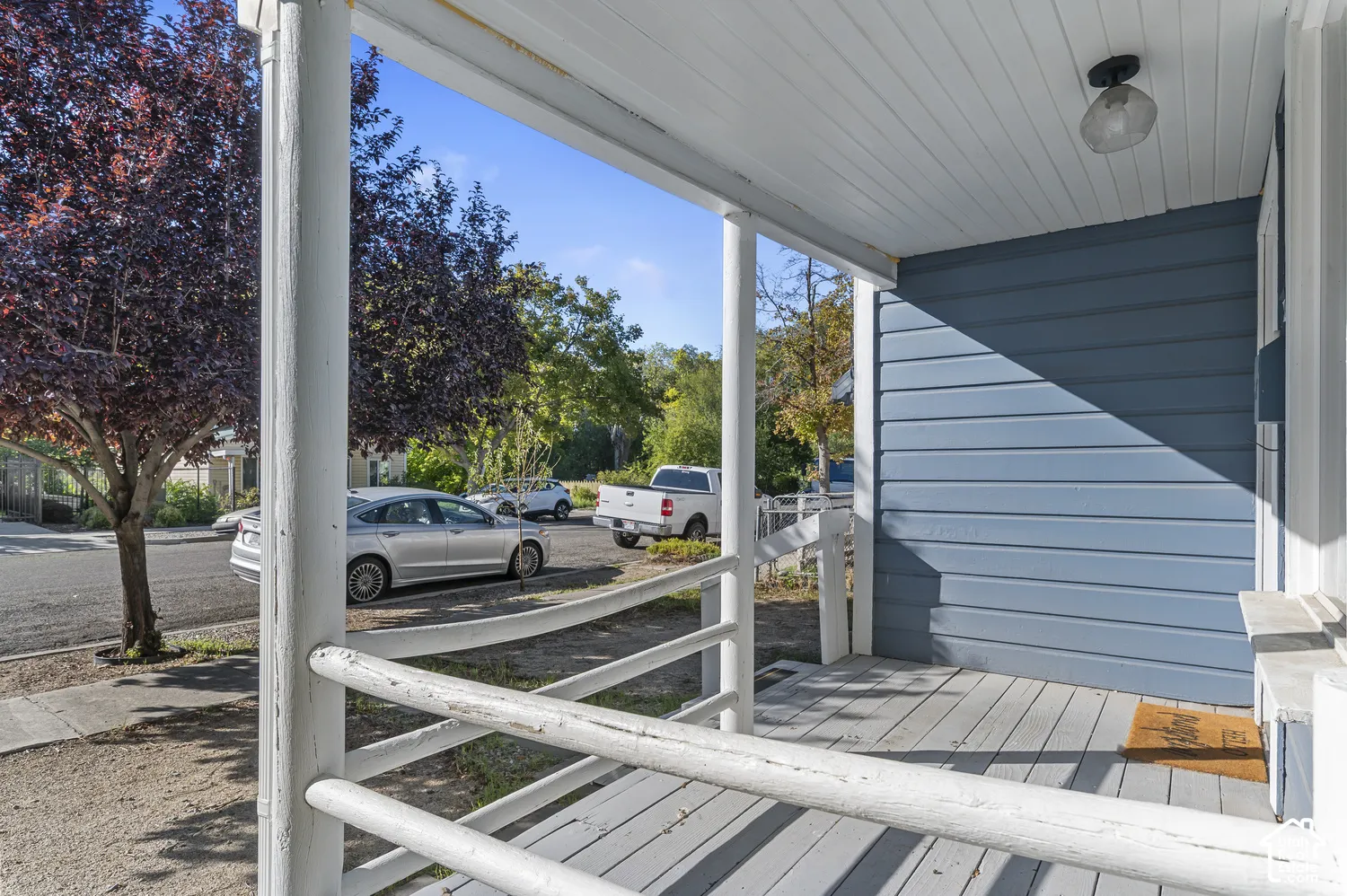 Covered front porch with painted wood siding and a beadboard ceiling