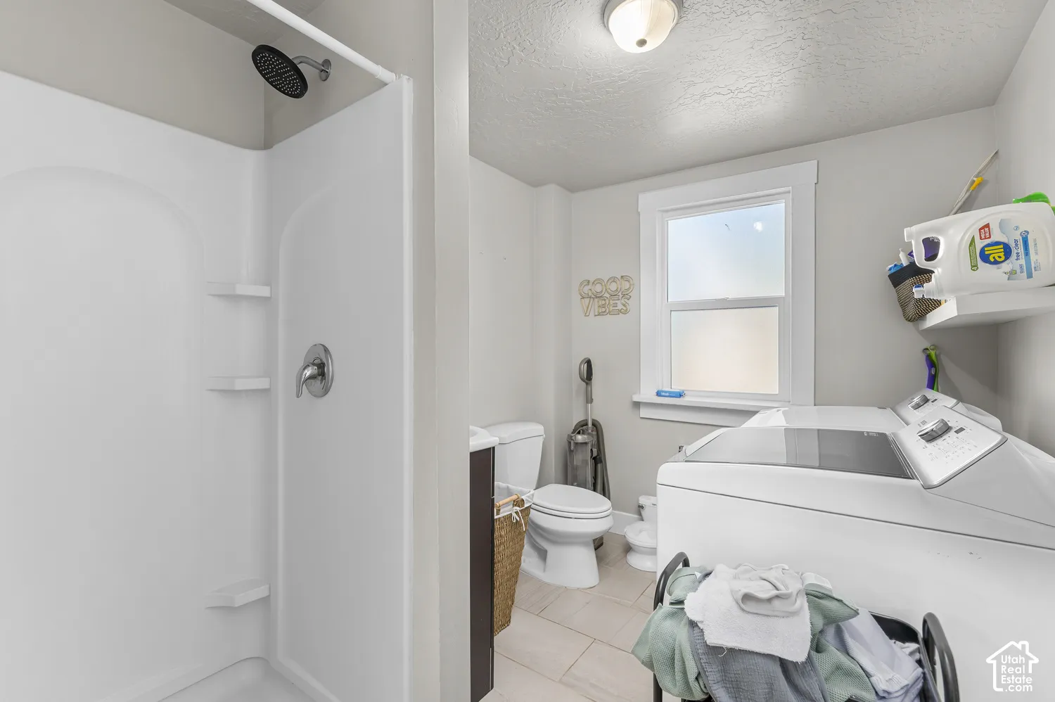 Full shower stall with integrated shelving, rain showerhead, and a single-handle faucet
