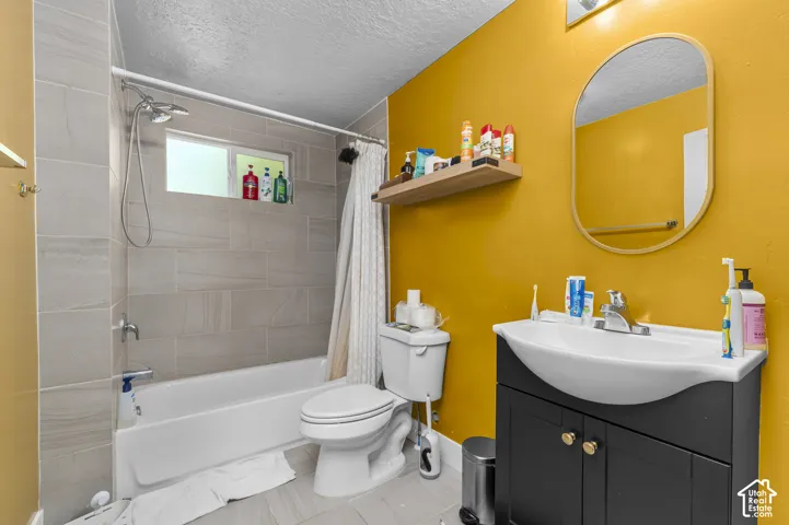 Bathtub and shower combination with light-toned rectangular wall tiling, a window, and a wall-mounted showerhead