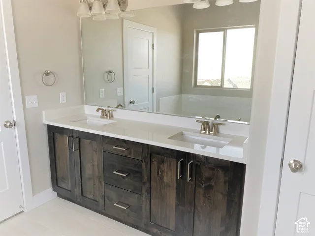 Dual vanity with dark wood-finish cabinetry, white countertop, and integrated sinks