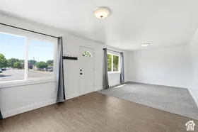 Bright interior space featuring white walls, wood-finish flooring, and a large window