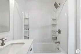 White vanity with a rectangular undermount sink and brushed nickel faucet