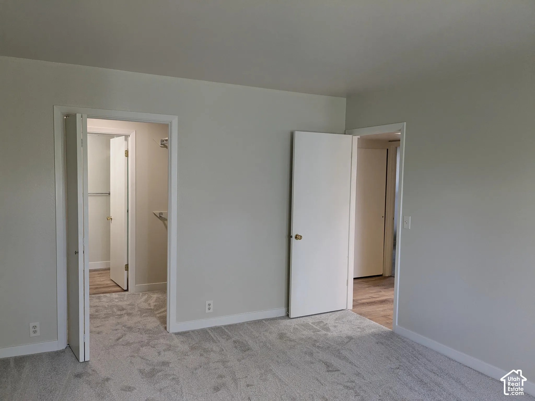 Spacious interior featuring multiple entry points with white-trimmed doorways, neutral wall finishes, and light-toned flooring throughout