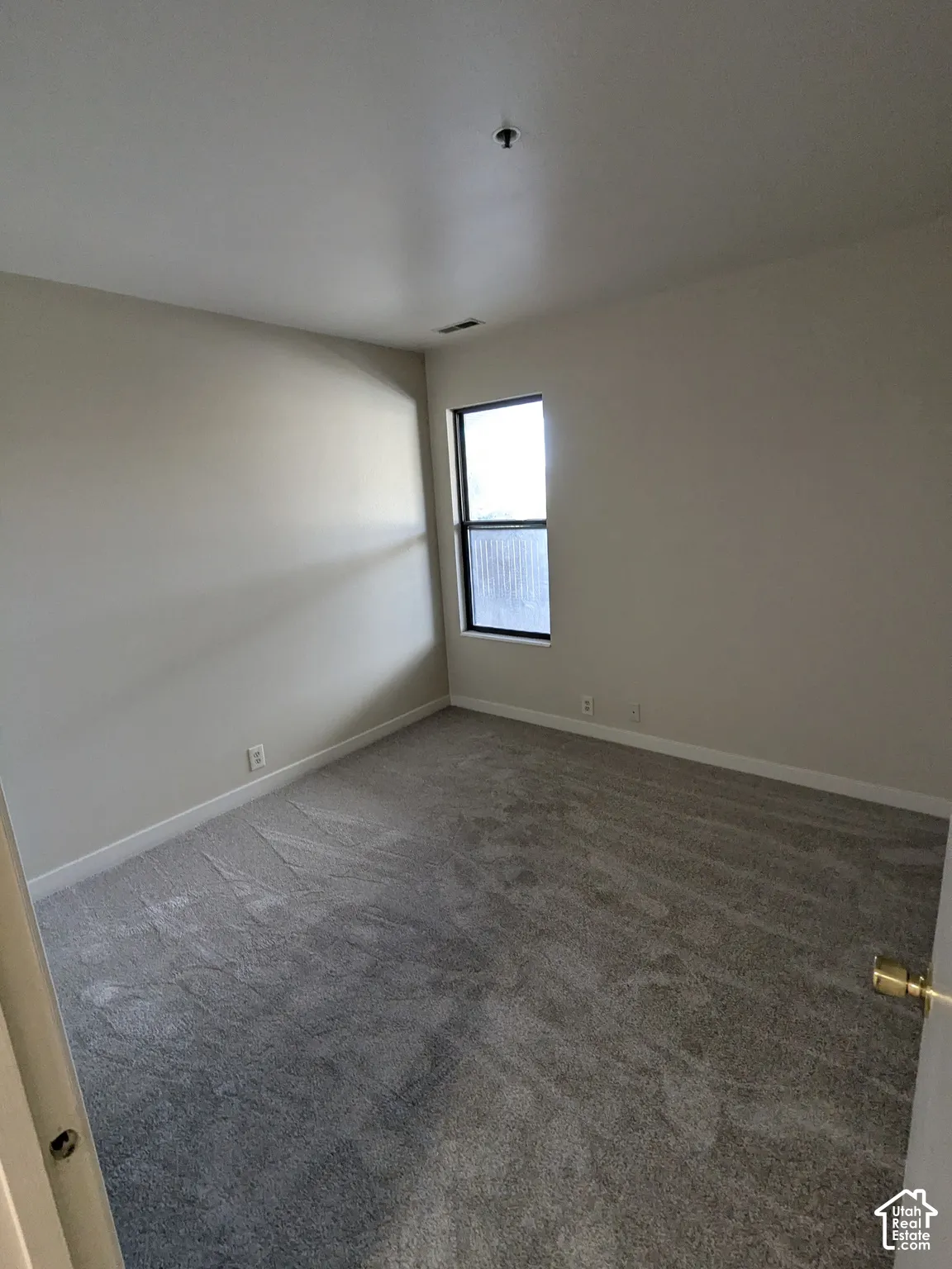 Recessed window with white trim, light gray wall paint, and gray carpeting
