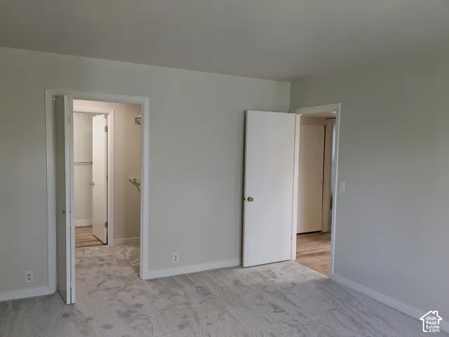 Spacious interior featuring multiple entry points with white-trimmed doorways, neutral wall finishes, and light-toned flooring throughout