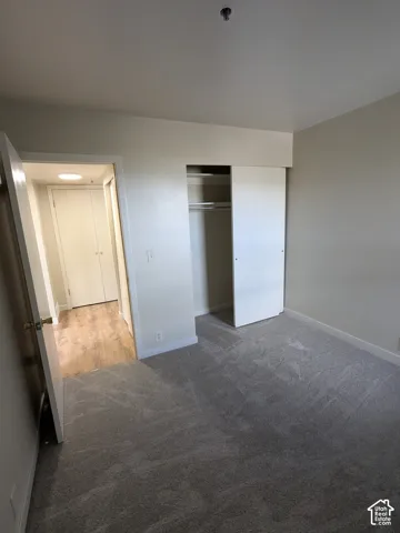 Spacious bedroom featuring neutral wall finishes, carpeted flooring, and a reach-in closet with shelving
