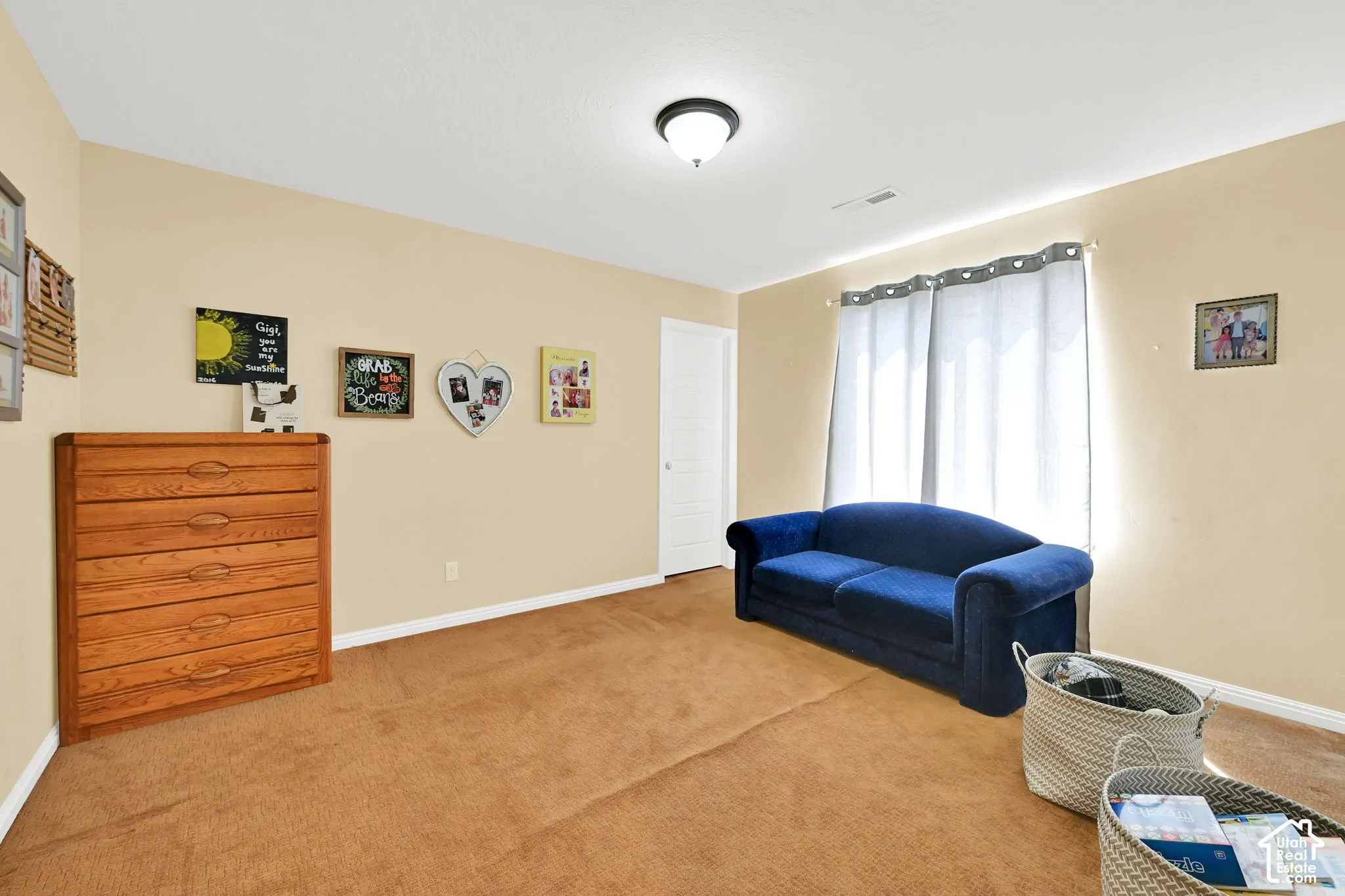Carpeted flooring, neutral wall color, and a window with natural light