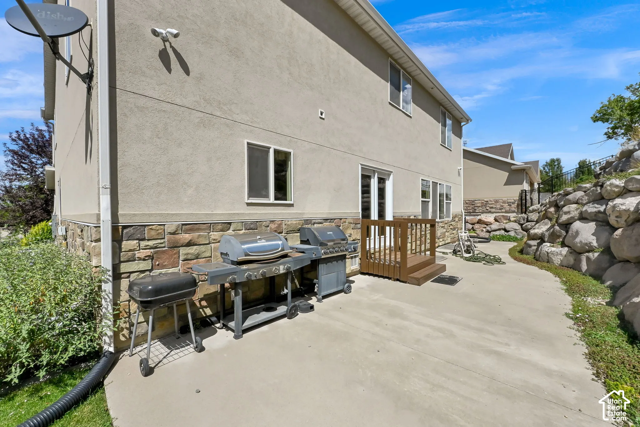 Rear exterior with stucco siding and stone veneer accents