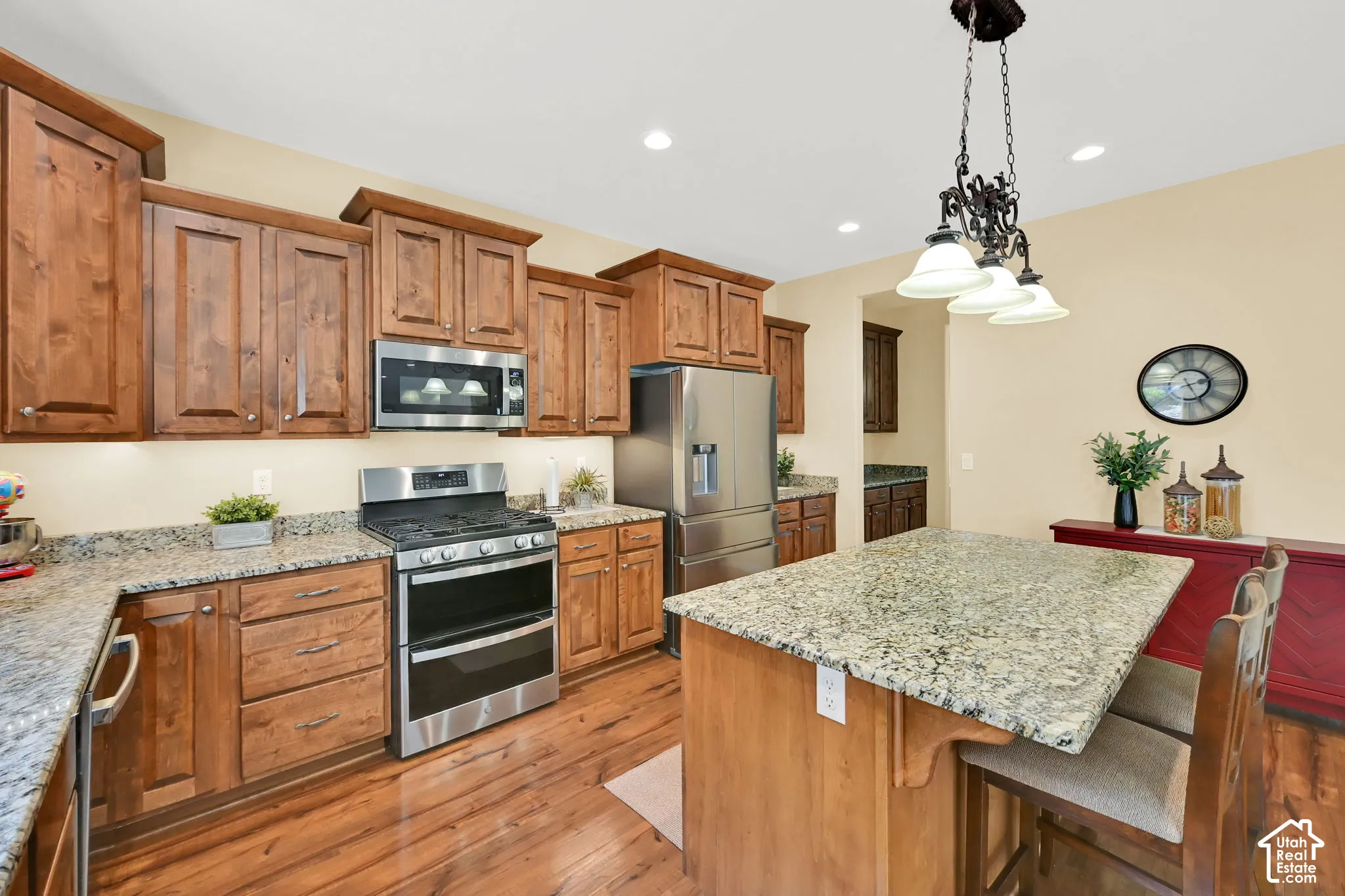 Wood-finish flooring, wood cabinetry, stone countertops, stainless steel appliances, and recessed lighting
