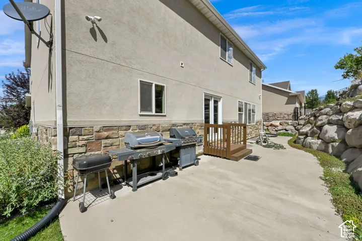 Rear exterior with stucco siding and stone veneer accents