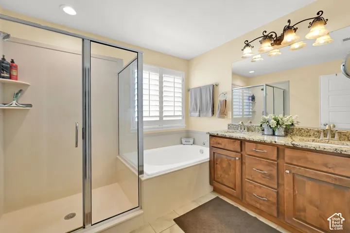 Walk-in shower with glass enclosure, separate soaking tub, dual vanity with granite countertop, and wood-finish cabinetry