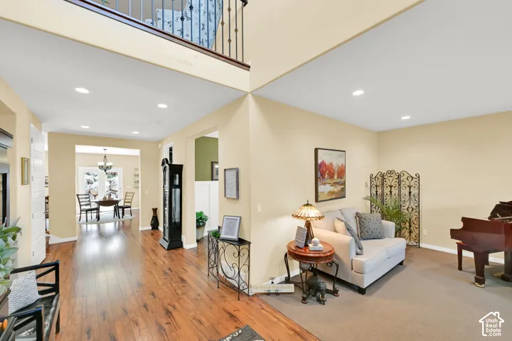 Wood-finish flooring, recessed ceiling lighting, and a second-story interior balcony with wrought iron railing