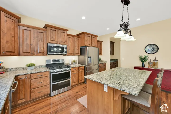 Wood-finish flooring, wood cabinetry, stone countertops, stainless steel appliances, and recessed lighting
