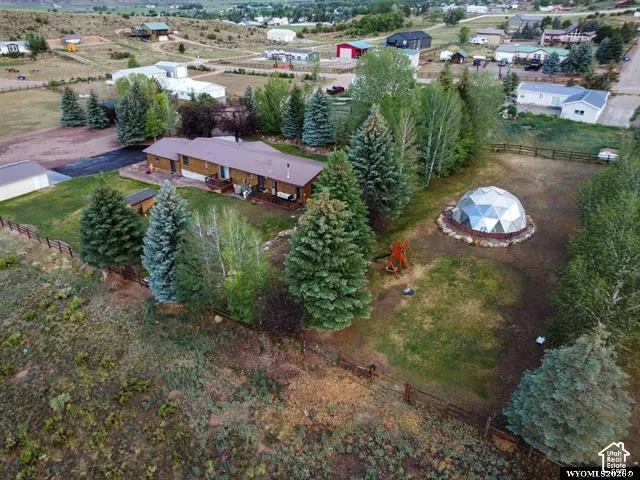Ranch-style residence with an expansive yard, mature evergreen trees, and a geodesic dome structure
